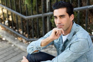 Attractive young handsome man, model of fashion in urban backgro