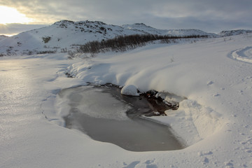 Mountain river under snow, Teriberka, Murmansk region, Russia