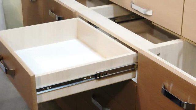 Master sets in a kitchen cupboard with drawers tray spoons and forks