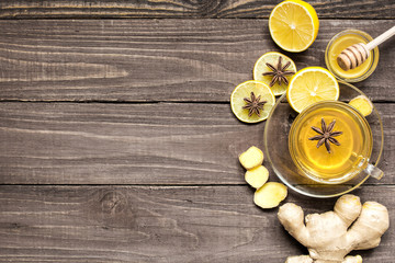 top view of transparent cup of ginger tea with lemon, spices and honey