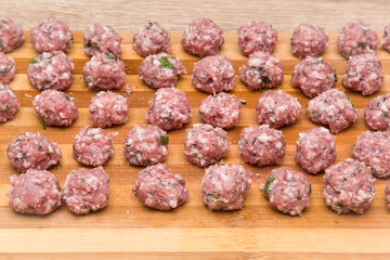 Meatballs with dill in there. Meatballs creation for soup or cutlets on the wooden board in the kitchen.