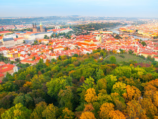Aerial view of Prague cityscape with Prague Castle, red roofs of Lesser Town, Vltava river, and trees on Petrin Hill on sunny day. Capital city of Czech Republic, Europe