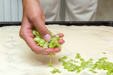 Hands put on the dough a pieces of rhubarb on the pan to bake rhubarb cake. Homemade pastries for Christmas time in the kitchen. Healthy eating lifestyle.