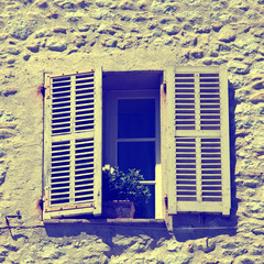 rustic window with old wood shutters in stone rural house, Provence