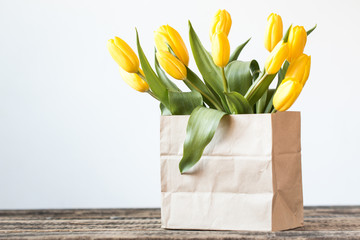 Valentines Day background with hearts and yellow tulips on wooden table