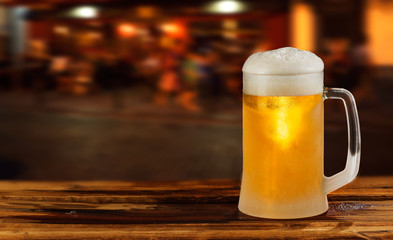 cold glass mug of beer with foam on the background of the street
