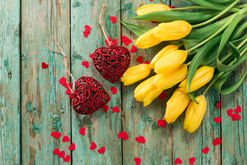 Valentines Day background with hearts and yellow tulips on wooden table
