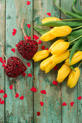 Valentines Day background with hearts and yellow tulips on wooden table