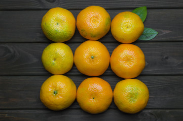 Fresh tangerines on dark grey wooden table, border copy space