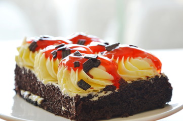 chocolate cake topping cream and dressing strawberry sauce on dish