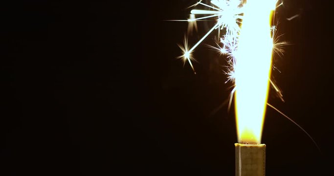4k Close up of flaming fountain firework lit by a candle