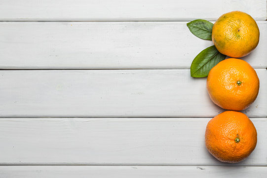 Fresh tangerines on white wooden table background, border copy space