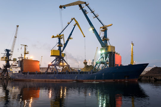 general cargo vessel in harbor at dusk