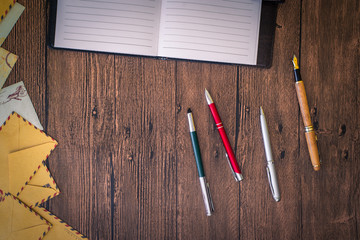 Obraz premium a wooden table with a notebook, envelopes and other stationery.
