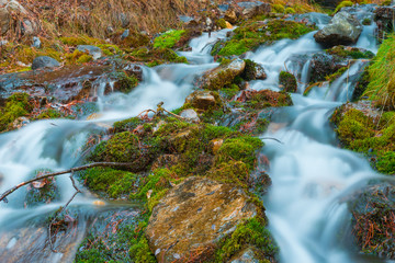 Fototapeta na wymiar Scenic forest spring waterfall in autumn