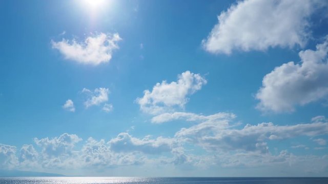 time lapse・逆光の青空に浮かぶ雲と太陽
