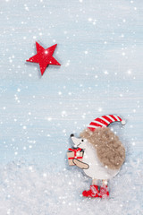 Christmas card with a hedgehog on a wooden background.