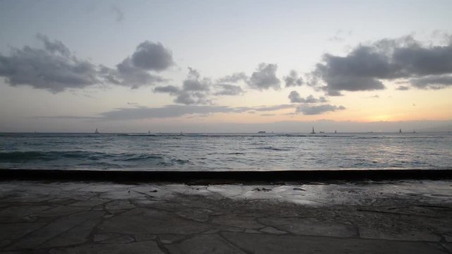 Sunset from Waikiki Beach as waves wash on to pier