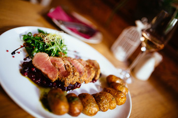 Restaurant food with fresh ingredients - pork tenderloin with grenaille potatoes and fresh salad