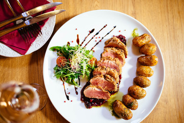 Restaurant food with fresh ingredients - pork tenderloin with grenaille potatoes and fresh salad