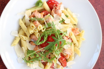 Restaurant food with fresh ingredients - pasta with dried tomatoes, parmesan and fresh rucola
