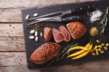 Delicious sliced roast duck breast closeup on a slate board. horizontal top view