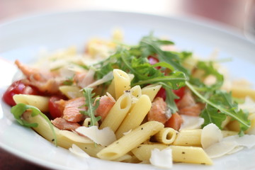 Restaurant food with fresh ingredients - pasta with dried tomatoes, parmesan and fresh rucola