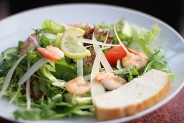 Restaurant food with fresh ingredients - salad with shrimps, parmesan and olive oil