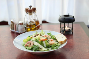Restaurant food with fresh ingredients - salad with shrimps, parmesan and olive oil