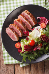 Festive roast duck breast and fresh mix green salad close-up. vertical top view