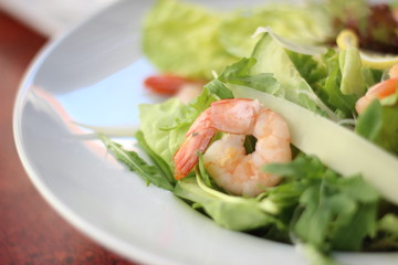 Restaurant food with fresh ingredients - salad with shrimps, parmesan and olive oil