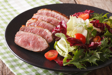 roast duck breast and fresh mix lettuce close-up. Horizontal