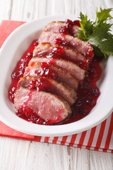 Festive food: roast duck breast with cranberry sauce close-up. vertical