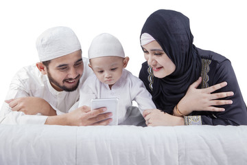 Arabian family use smartphone on bed