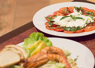 Restaurant food with fresh ingredients - tomatoes with mozzarella and fresh basil