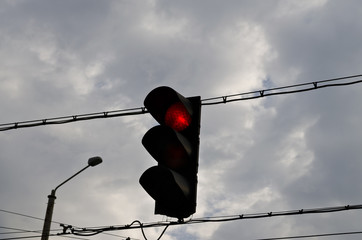 Traffic light with red light against the morning sky