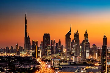 Foto op Plexiglas Een prachtig uitzicht op de skyline van Dubai, Verenigde Arabische Emiraten gezien vanaf Dubai Frame bij zonsondergang met Burj Khalifa, Emirates Towers, Index Building en DIFC © Sophie James