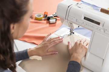 Close up of beautiful woman's hands using a sewing machine