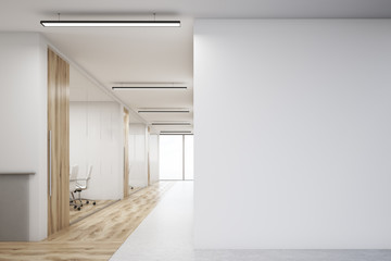Office with blank wall and row of meeting rooms