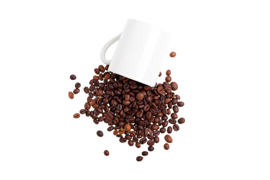 Overturned white mug with coffee beans, top view