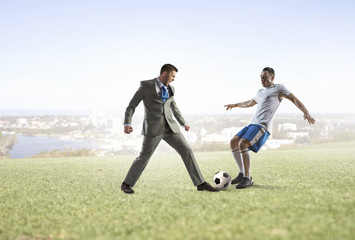 Obraz na płótnie Canvas Businessman kicking soccer ball . Mixed media