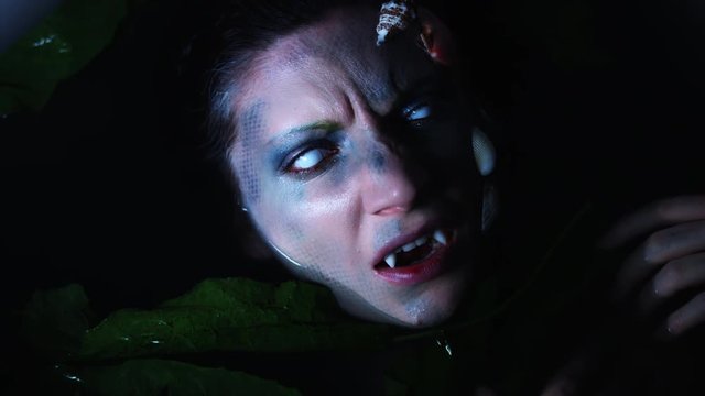 4k Halloween Shot of a Horror Woman Mermaid Posing in Water with Vampire Teeth