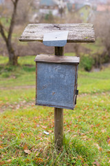 Very old tin mailbox on a wooden post