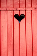 Red, wooden shutter with a heart