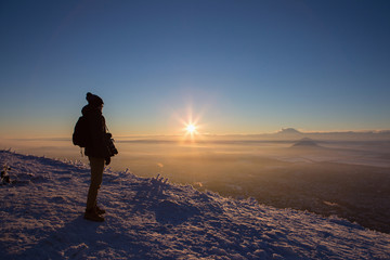 Male photographer on the mountain top. Winter, dark, night, snow.