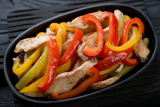 Closeup of fajitas with chicken fillet and colorful bell peppers