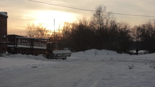 tractor cleans snow