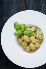 White glass plate with italian potato gnocchi and basil