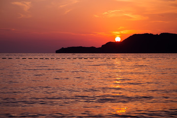 Beautiful golden orange sunset at sea pebble beach
