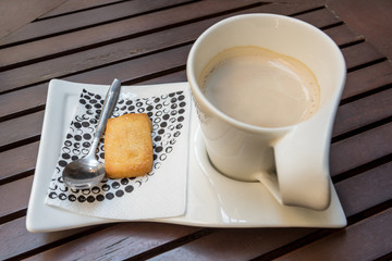 Cappuccino or latte coffee with biscuit on wood table